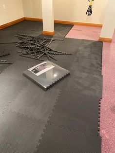 a laptop computer sitting on top of a floor covered in black plastic planks and pink carpet