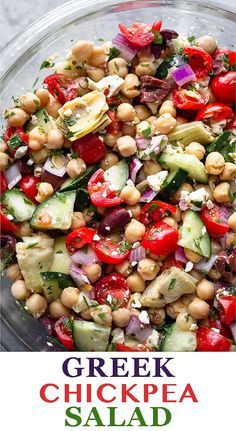 greek chickpea salad with tomatoes, cucumbers and herbs in a glass bowl