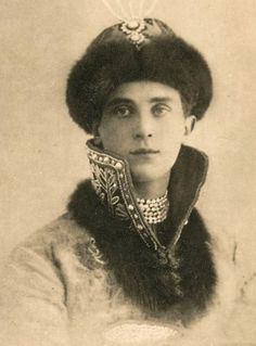 an old black and white photo of a woman wearing a fur hat with pearls on it