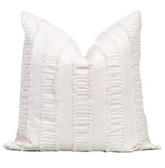 a white pillow with ruffles on the front and back of it, against a white background