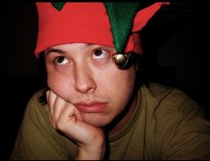 a man wearing a red and green elf hat