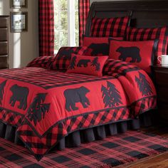 a red and black bed in a bedroom next to a dresser with two lamps on it