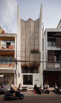 two motorcycles parked in front of a tall building