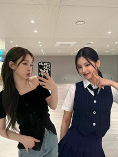 two young women taking pictures with their cell phones