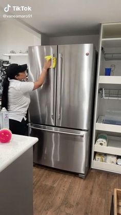 a woman is cleaning the refrigerator in her kitchen