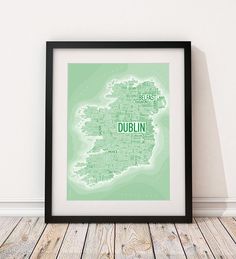 a framed map of dublin in grey and white on a wooden floor with a black frame