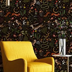 a yellow chair sitting in front of a wallpapered with animals and plants on it