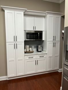 a kitchen with white cabinets and stainless steel appliances