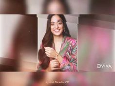 a woman with long hair is smiling and posing for a photo in front of some blurry background