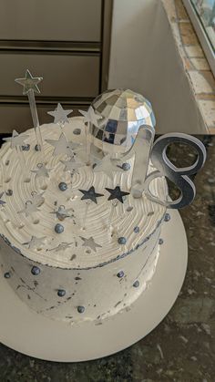 a white cake with silver stars and scissors on top