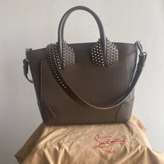 100% Authentic. A Brand New, Christian Louboutin Two Handle, Spike Large Eloise Bag In Taupe Leather Item Description: Sexy Christian Louboutin Eloise Bag In Taupe Leathersize Large. Luxurious Leather, Artisan Hollywood Glam Silver Studs And Hardware, Including 4 Miniature Heels. Adiustable Removable Strap, Can Be Worn Crossbody Too. The Bag Has One Interior Pocket, 2 Snap Exterior Pockets, And One Exterior Zip Pocket. Comes With Original Dust-Bag Measurements 11"H 15"W 6"D Lightly Used With Scr Red Bottom Heels, Louboutin Bags, Sparkly Heels, Taupe Leather, Leather Satchel Handbags, Leather Artisan, Bag Measurements, Hollywood Glam, 6 D