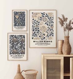 three framed art pieces hang on the wall above a wooden cabinet and wicker basket