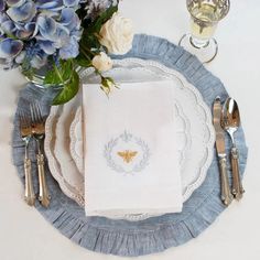 a place setting with blue flowers and silverware