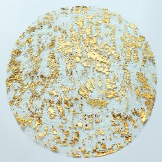 a round gold and white plate on a blue tablecloth with golden flecks