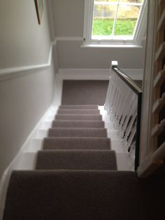 the stairs lead up to an open window in a house with carpeted flooring