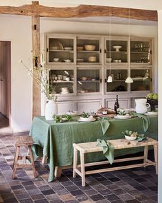 a dining room with green table cloths and chairs