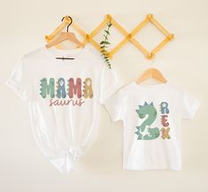 two t - shirts with the words mama and baby are hanging on a clothes rack