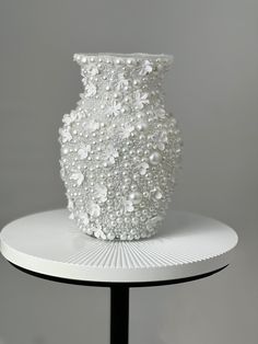 a white vase sitting on top of a table