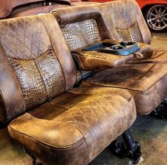 two brown leather seats sitting next to each other