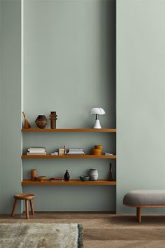 a living room with green walls and wooden shelves