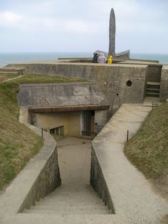 the entrance to an old fort with a statue in the background and grass growing on the ground