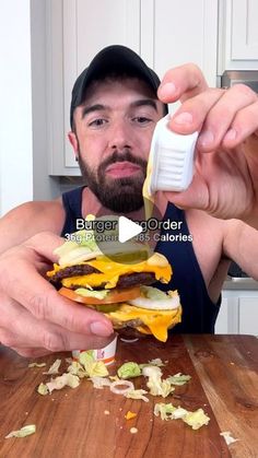 a man is eating a cheeseburger on a cutting board