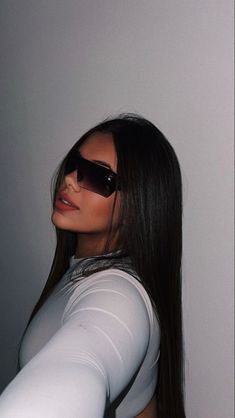 a woman wearing sunglasses is posing for the camera