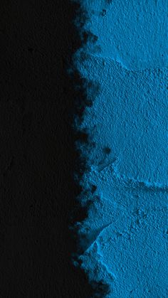 a black wall with blue paint on it