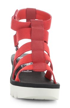 Take your casual look up a notch with this strappy sandal grounded by a lightly cushioned footbed and wedge heel. 2 1/2" heel; 1" platform Adjustable ankle strap with hook-and-loop closure Cushioned footbed Synthetic and leather upper/textile lining/rubber sole Made in Portugal Casual Synthetic Wedge Sandals With Red Sole, Red Wedge Sandals With Heel Strap For Beach, Red Synthetic Wedge Sandals With Heel Loop, Adjustable Red Sandals With Removable Insole, Casual Red Strappy Sandals, Casual Sandals With Ankle Strap And Red Sole, Casual Wedge Sandals With Strap, Lipstick Red, Fly London