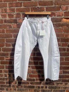 The highly anticipated vintage lasso jean from b sides cut in vintage white denim.  signature slouchy fit; kinked and cropped leg shape.  each pair is one-of-a-kind and will vary in caste color and fade pattern.  the vintage lasso jean is made with authentic vintage levi's 501s collected in the american west.  details + fit  - slouchy relaxed fit sits off the waist at the high hip - vintage men's classic mid-rise cut with original button fly closures  - shaped outseam and cut off frayed hem - ea Levi 501s, Caged Sandals, Black Tank Dress, Black Aviators, Neon Purple, American West, Boyfriend Tee, Engineered Garments, Ruched Dress