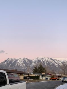 a white truck parked in front of a snow covered mountain