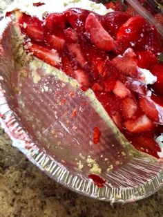 a pie with strawberries in it sitting on top of a counter