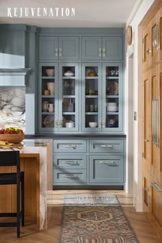 a kitchen with blue cabinets and an area rug