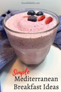 a smoothie in a glass with strawberries and blueberries on the top is ready to be eaten