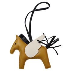 Bring a little flair to your everyday handbag! The key to making fashion effortless is having fun and putting your own unique twist on your ensembles. This is a tiny horse figure that will be sure to add a bright touch to your favorite accessory. This cute charm is made of vibrant camel Milo lambskin, which is used in the making of Hermes gloves, and known to be named after Venus de Milo and to be smooth and glossy. There is a natural beauty of this type of leather. It features a black leather l Hermes Pegasus Charm, Hermes Horse Charm, Hermes Gloves, Hermes Charm, Hermes Horse, Hermes Clutch, Horse Rodeo, Tiny Horses, Chanel Coat