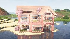 a large pink house sitting on top of a body of water