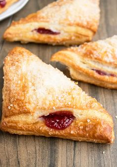 three pastries on a wooden table with one slice missing from the pie and another half eaten