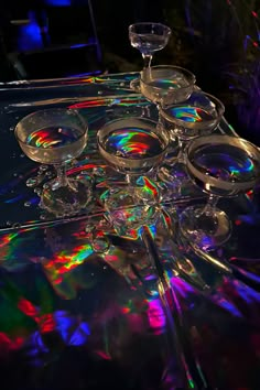 an array of wine glasses sitting on top of a table covered in holographics