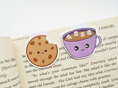 an open book with some stickers on it's pages and a cup of coffee in the middle