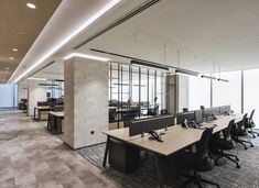 an empty office with desks and chairs in the middle, along with large windows