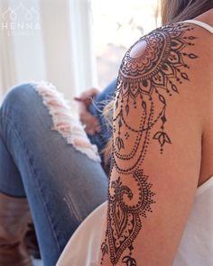 a woman's arm with henna tattoos on it