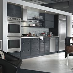 a modern kitchen with stainless steel appliances and gray cabinets