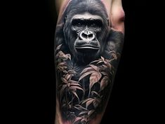 a man's arm with a gorilla on it and bamboo leaves in the foreground