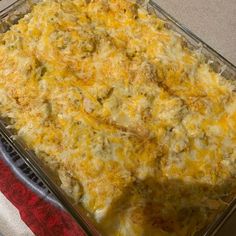 a casserole dish with cheese and meat in it sitting on a red towel