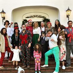 a group of people dressed in christmas pajamas pose for a photo on the front steps of a house