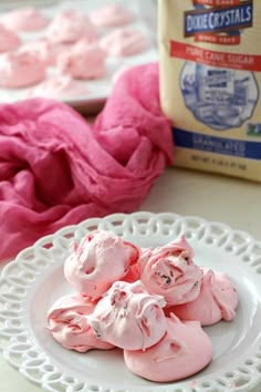 pink marshmallows on a white plate next to a bag of rice krispy kreme