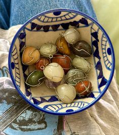 a blue and white bowl filled with lots of marbles