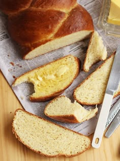 sliced bread and butter sitting on top of a piece of paper next to a knife