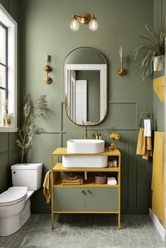 a bathroom with green walls and yellow accents on the vanity, mirror, toilet and sink