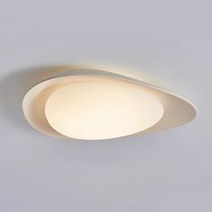 a close up of a ceiling light on a white wall with a gray back ground